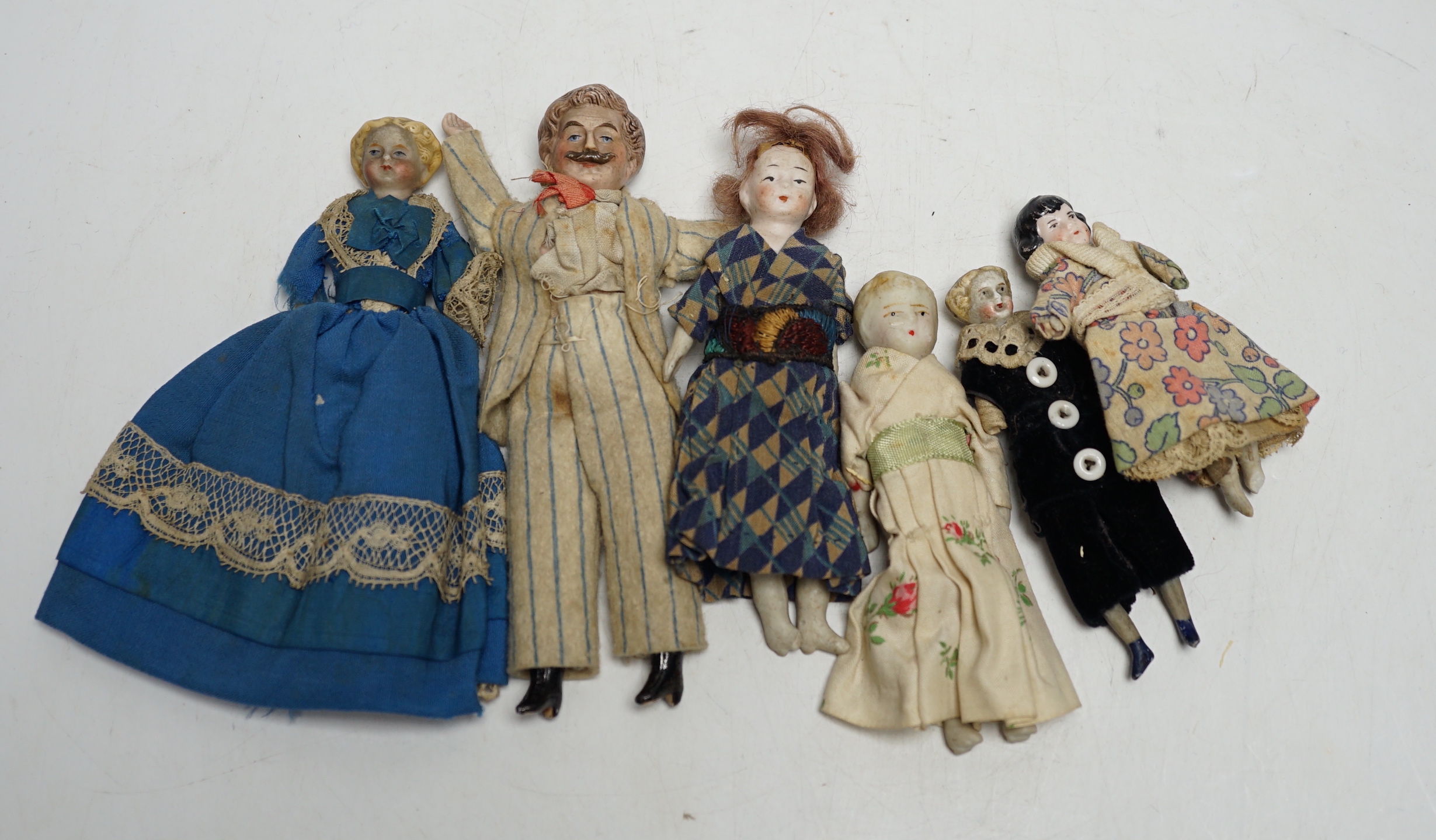 Six doll's house dolls, two c.1860 and a male figure with moustache, two other bisque later figures and one small doll, damaged